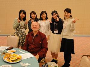 ピースをした5名の女性とリックさんが記念撮影をしている写真