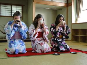 浴衣を着たリズモー市の女子学生3人が、和室で正座をし、お茶を飲んでいる写真