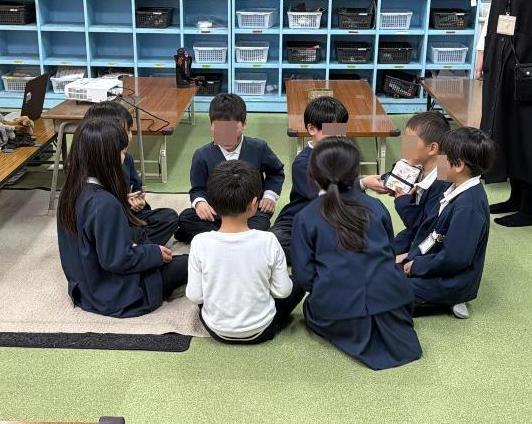 8人の子どもたちが床に円になって座り、オーストラリアのゲームをしている様子。