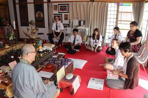 弥勒寺で座禅を組み住職の講話を聞いているリズモー市の学生達の写真