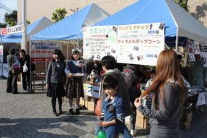 テントの前でラミントンの説明をしている女子学生2名の写真