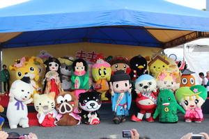 テントの下にたくさんのマスコットキャラクターが集合している写真