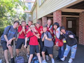 日本人学生2人と、赤いシャツやグレーのスエットを着たリズモー市の学生7人が笑顔で記念撮影をしている写真