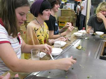 外国人の学生4人が鉄板の前で食事をしている写真