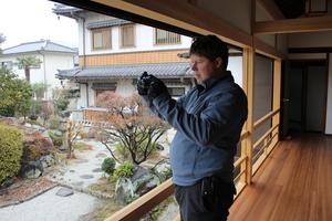 専立寺の廊下から庭園をカメラで撮影しているキャメロンさんの写真