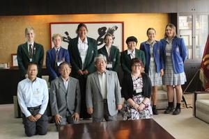 派遣学生7名と引率の先生、市長と関係者の人が並んで記念撮影をしている写真