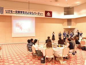 リズモー交換学生さよならパーティーと書かれた幕の下で学生達が挨拶をしている写真