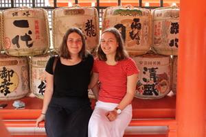 沢山積まれたお酒の樽の前で記念撮影をしているリズモー市の女子学生の写真