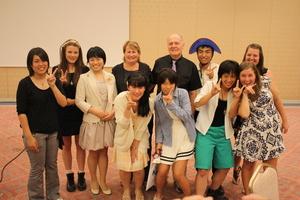 リズモー市の関係者の男性と女性、女子学生3人と、パーティーに参加した日本人6人の方々と記念撮影をしている写真