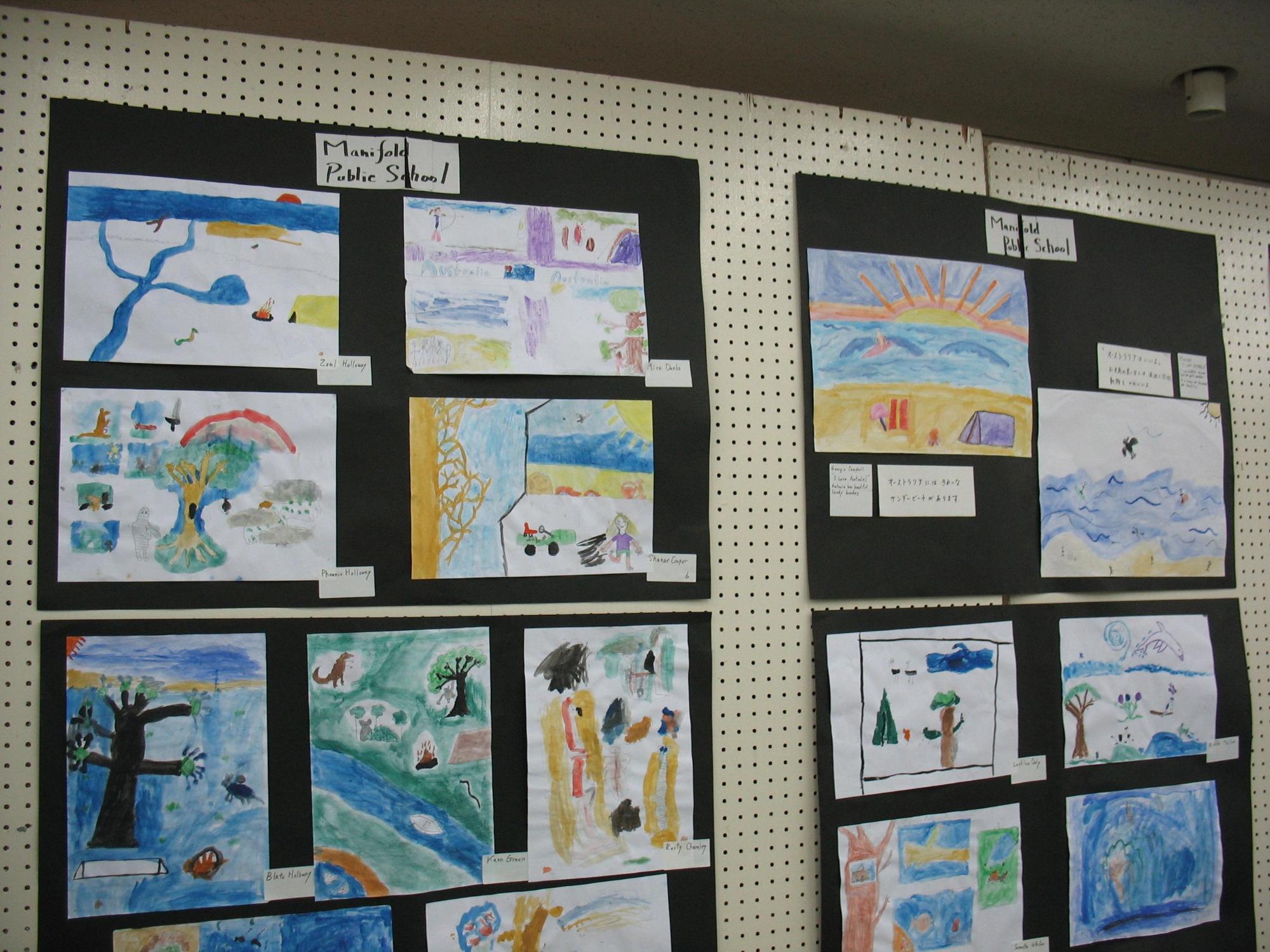 学校名が書かれたタグの下にそれぞれ9枚の絵と6枚の絵が展示されている写真