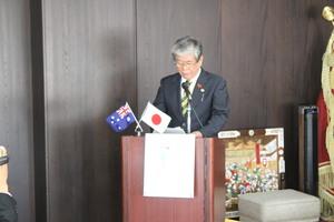 小さなオーストラリアと日本の国旗が飾られた演台で挨拶をしている市長の写真