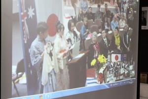 リズモー市滞在中の、派遣学生3名のスピーチをスクリーンに映し出している写真