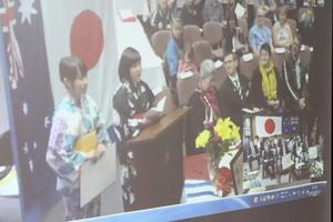 リズモー市滞在中の、派遣学生2名のスピーチをスクリーンに映し出している写真