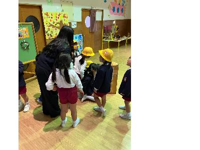 1人の女性と5人の園児たちが展示会を見つめている様子