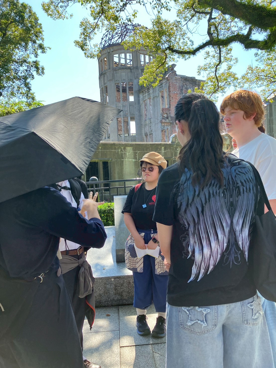 リズモー市の学生4名と、引率者1名が原爆ドームを訪問し、ガイドから説明をしてもらいました。