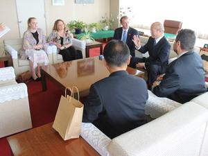 議長の話を椅子に座り真剣に聞いている4名の外国人の方と関係者の方の写真