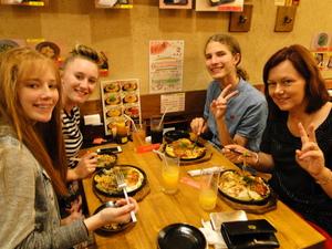 リズモー市の女子4名が同じテーブルに座り広島焼を食べている写真