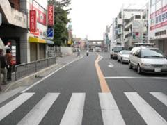 礒野東町交差点右側道路に車が赤信号で停車している風景写真