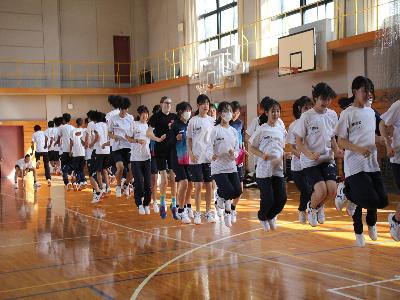 高田商業高校の生徒たちとリズモー市の学生が体育の授業で大縄跳びをしている様子