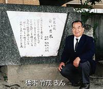 若い日本の記念碑の前で記念撮影をしている橋本竹茂氏の写真
