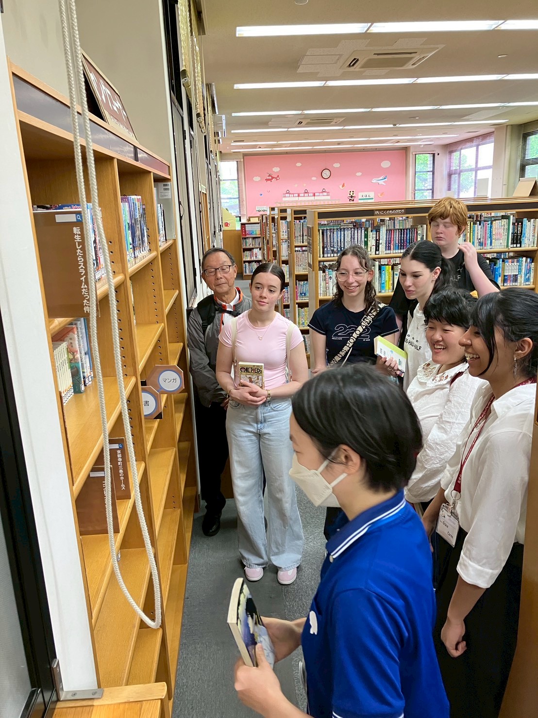 リズモー市の学生5名と、引率者1名が図書館を訪問し図書館員から人気のある図書の説明を受けました