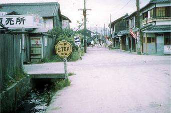 道の端に一時STOP停止と書かれた看板が設置された昔の旭北町交差点の写真