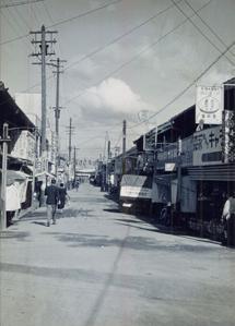 近鉄駅前商店街を歩いている人達を後方から写した白黒写真