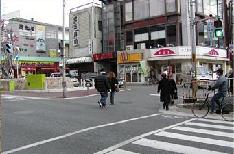 近鉄南大阪線高田市駅前に数名の人が歩いている写真