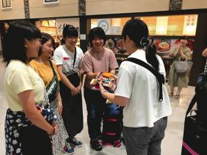 女子学生5名が円になりお菓子を見ている写真