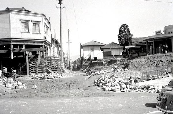 手前の道路を壊し奥に建物が残っている白黒写真