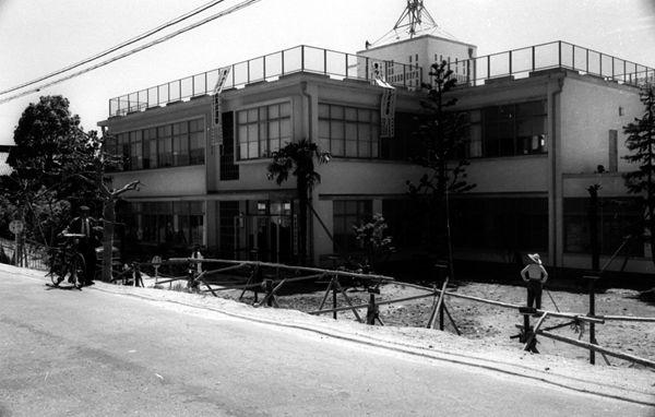 道路右奥に2階建ての高田警察署が写っている白黒写真
