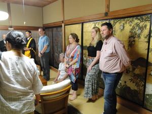 4名の外国人と参加者達が専立寺で住職の方の話を聞いている写真