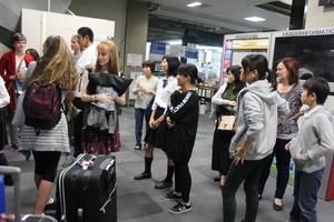 リズモー市からの学生が空港で荷物を受け取っているところをホストファミリーの方が見ている写真