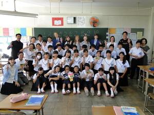 教室内でリズモー市の学生5名と高田西中学校の生徒、先生方でピースをして記念撮影をしている写真