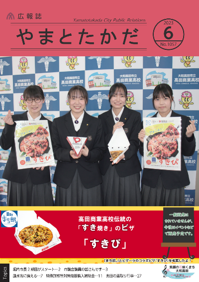 高田商業高校「まち部。」の女子学生4人が高田商業高校伝統の「すき焼き」とピザを組み合わせて「すきぴ」というピザを考案し、ピザPRの看板を持ってピザを宣伝しているようす