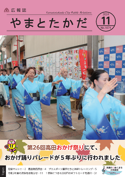 広報誌11月号表紙 第26回高田おかげ祭りにて、5年ぶりに行われたおかげ踊りパレードの様子。青い着物を身にまとった文化協会の方々が、おかげ踊りを踊りながら片塩商店街を歩いています。