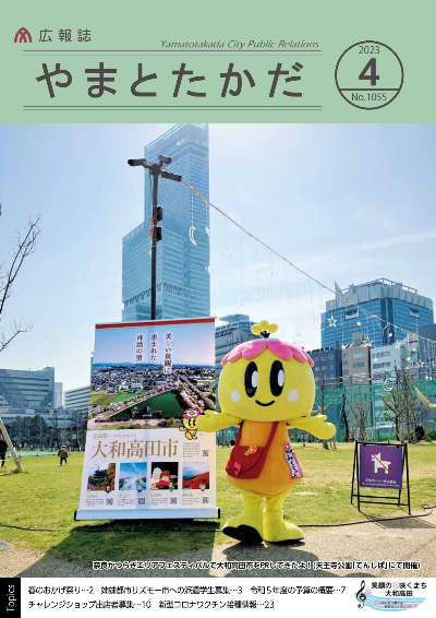 広報誌4月号表紙  大和高田市のマスコットキャラクター「みくちゃん」が、天王寺公園の「てんしば」で行われたイベント「奈良かつらぎエリアフェスティバル」で両手を広げて大和高田市をPRしているようす